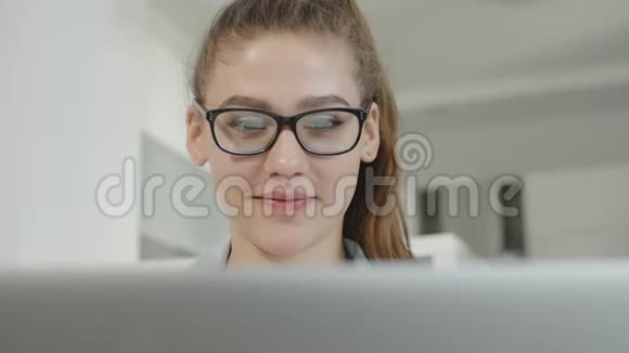 年轻的少女正在家里使用笔记本电脑在社交网络上聊天微笑着视频的预览图