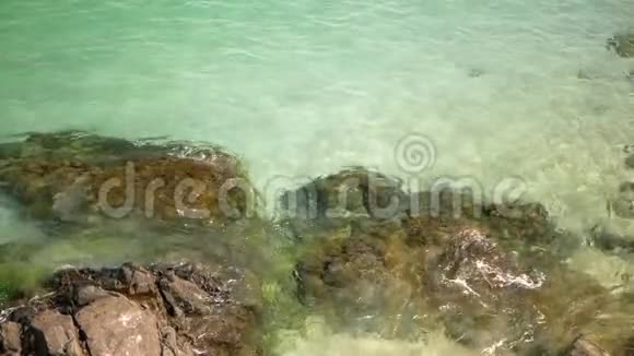 海浪拍打在岩石海岸从水中可以看到沙子和石头视频的预览图