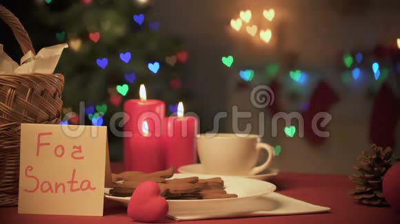 餐桌上的圣诞老人便条杯可可和姜饼女孩微笑着拍照视频的预览图