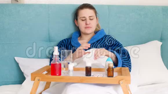 4k视频年轻患病妇女躺在床上用鼻喷雾视频的预览图