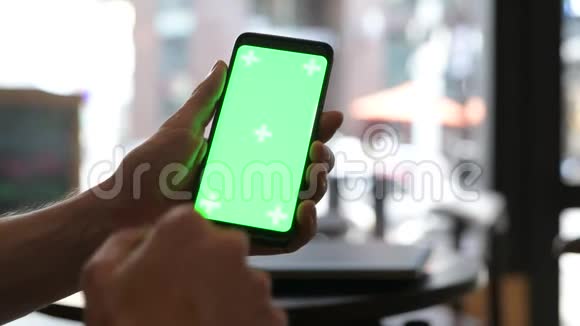 餐厅使用绿色屏幕手机的人手特写视频的预览图