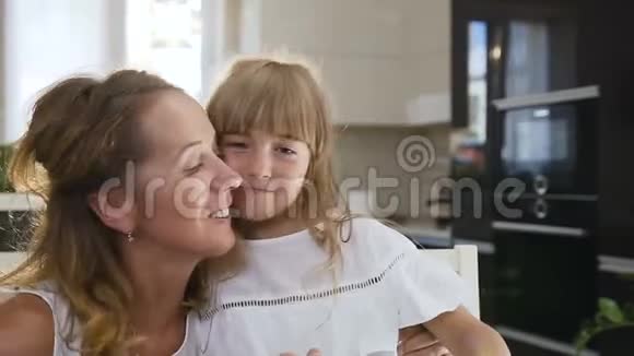 一对年轻的母女在室内的肖像特写幸福的母亲和女儿的笑脸视频的预览图