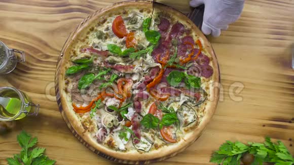 在披萨店的木桌上用滚刀将披萨切好上景厨师切热披萨视频的预览图