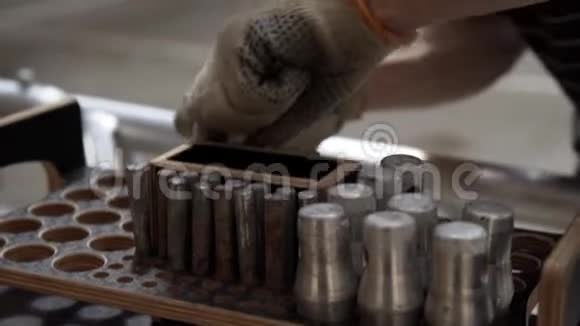 手工手套从带有圆孔的木箱中取出圆筒状的金属销视频的预览图