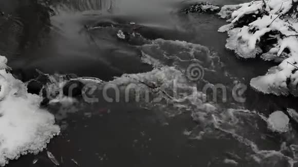 水流在河里离水很近岸上的雪和冰柱视频的预览图
