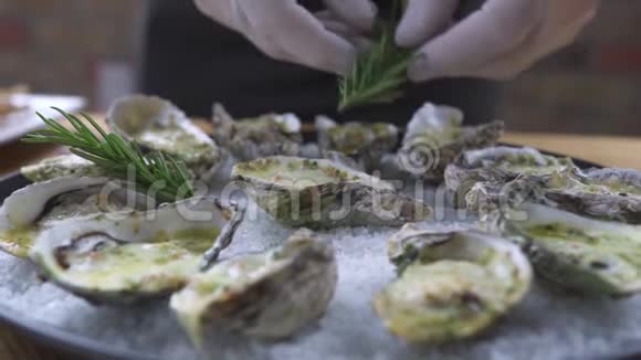 食品设计造型理念厨师在盘子里用迷迭香装饰牡蛎海鲜餐厅的食品装饰视频的预览图