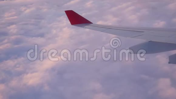 飞行中的飞机在天空中的机翼在云中的夕阳下飞行视频的预览图