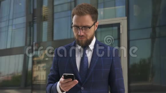 一位留着胡子的商人戴着眼镜穿着蓝色西装看着摄像机视频的预览图