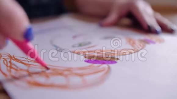 女孩用毛毡尖笔在一张白纸上画了一幅五颜六色的画特写和标记美丽的景色视频的预览图