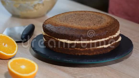 糖果师把奶油放在蛋糕的顶部面包师平滑蛋糕与鲜奶油糖霜视频的预览图