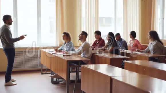 年轻的学生举手回答老师问题而留胡子的教授则在讲话视频的预览图