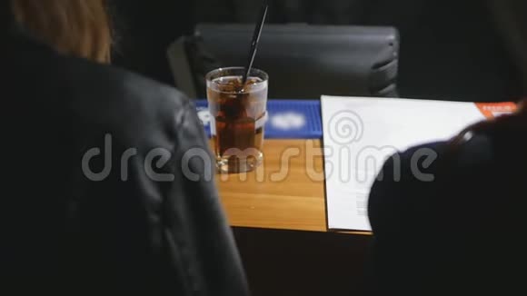 一个穿皮夹克的女孩在酒吧点了一杯鸡尾酒视频的预览图