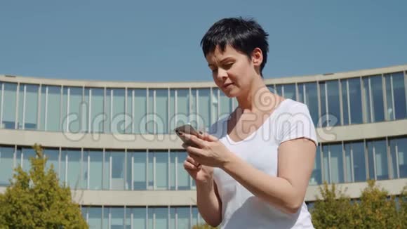 商务女性坐在办公楼前打电话视频的预览图