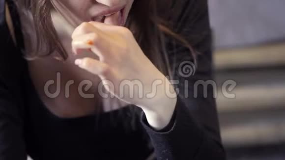 年轻女孩在咖啡馆里吃快餐特写镜头咬掉一块炸薯条快餐的概念视频的预览图