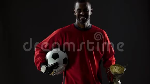 激动人心的黑人足球冠军拿着奖品和球运动奖励快乐视频的预览图