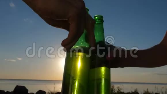 在日落时用特写手品尝啤酒瓶视频的预览图