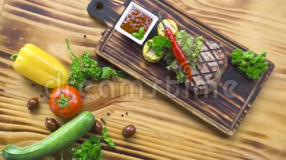 烧烤肉牛排组成俯视图用红辣椒香草玉米和番茄酱在木板上烤牛排视频的预览图