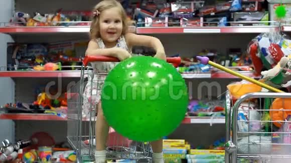 孩子们玩具商店超市里的一个孩子坐在购物车里视频的预览图