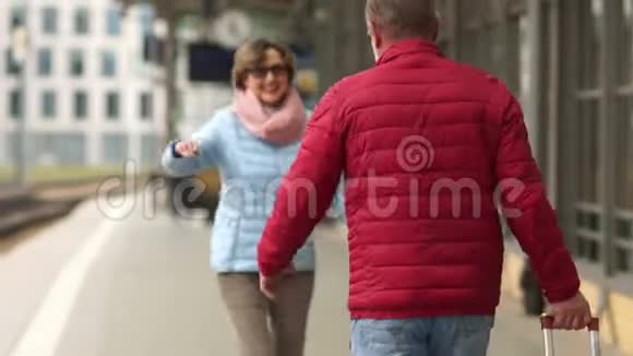 成熟的女人从旅途中在车站遇见她的丈夫期待已久的会议视频的预览图