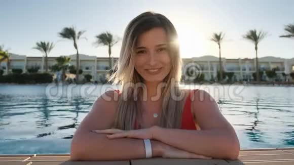 特写脸像拍摄的微笑少女看着镜头穿着红色泳衣穿着蓝色泳衣的美女视频的预览图