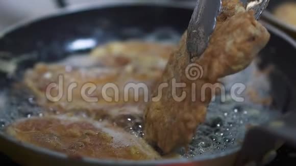 美味多汁的小切片是在一个煎锅中煮熟的里面有鼓泡的葵花籽油厨师用钳子夹一块视频的预览图