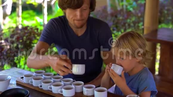 父亲和儿子在一家热带咖啡馆里品茶视频的预览图