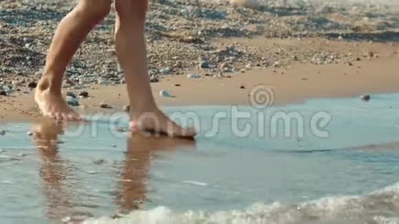 人类的双腿触着海水突然跑掉了沙滩上女孩的脚视频的预览图