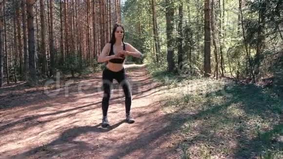 女人在湖边的树林里做体育锻炼慢动作视频的预览图