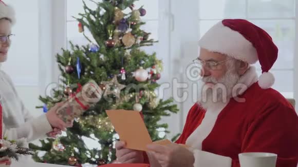 小男孩在看祝福信时圣诞老人送礼物视频的预览图