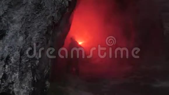 黑暗洞穴里的旅行者库存录像带着红色火炬的人穿过黑暗洞穴的狭窄隧道危险和危险视频的预览图