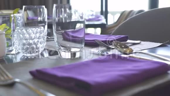 餐桌设置餐厅概念把棉布餐巾眼镜勺子叉子和刀子都贴在餐桌上视频的预览图