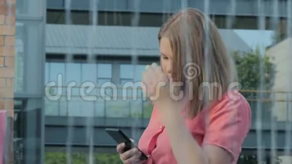 可爱的年轻白种人女人在阳光明媚的城市街头散步和朋友聊天快乐的女孩使用视频的预览图