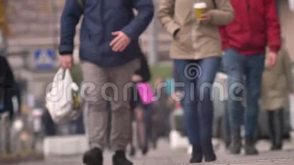在城市道路上匆忙行走的行人腿的特写镜头视频的预览图