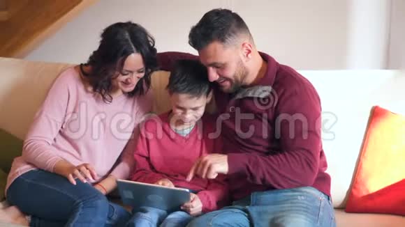 在玩数码平板电脑游戏的同时庆祝成功的幸福家庭视频的预览图