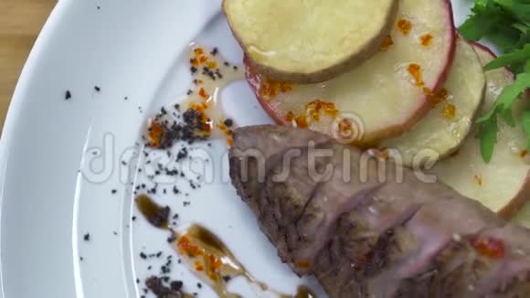 顶部的烤肉牛排与炸土豆在白色盘子接近食物背景肉片与蔬菜视频的预览图