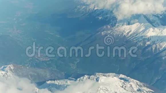 山谷中的雪山峰和遥远的高山小镇视频的预览图