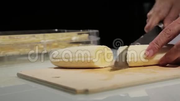妇女使用菜刀滑动切割香蕉在木切割板上香蕉切片处理干果视频的预览图
