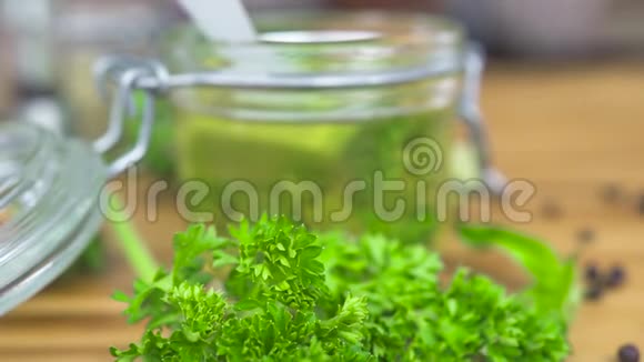 玻璃罐中的橄榄油用于木制桌子上烹饪的草药希腊菜用的圣母橄榄油调味料和香料视频的预览图