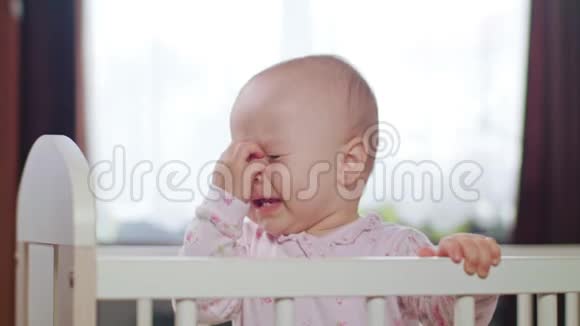 婴儿站在家里的婴儿床上哭泣视频的预览图