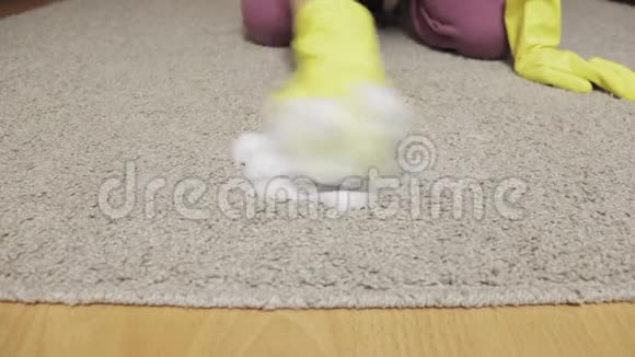穿黄色橡胶手套的女人用海绵和泡沫清洁地毯视频的预览图