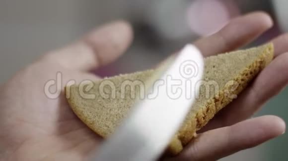 男性手缓慢地在厨房的三角形面包片上撒黄油视频的预览图