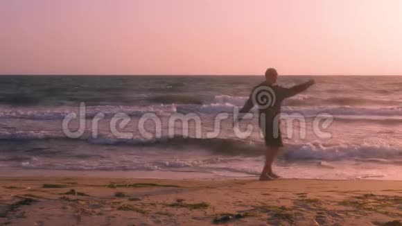 运动健将在日出时在海滨运动前做手臂旋转以热身运动视频的预览图