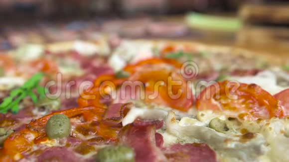 餐厅桌上有西红柿和培根的热比萨意大利原装披萨配西红柿奶酪橄榄视频的预览图