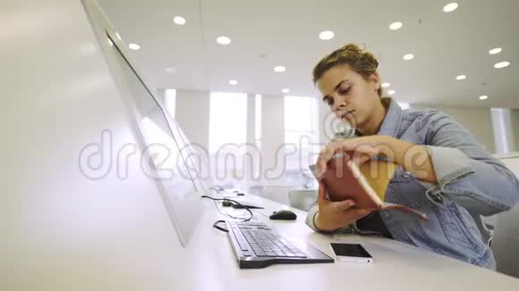 在电脑附近学习的年轻女子视频的预览图