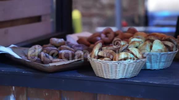 不同的包子面包和甜甜圈放在木托盘和小篮子里视频的预览图