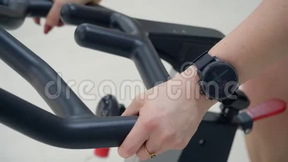 将健身手环贴在运动健身车上的运动女子手腕上视频的预览图
