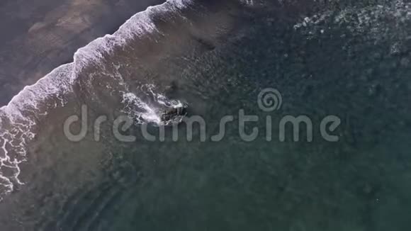 阿里尔无人驾驶飞机拉回平静的海浪卷成黑色沙滩海岸天堂视频的预览图