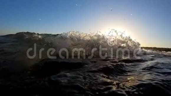 日落时分波浪缓慢移动在泡沫般的水面下潜水视频的预览图