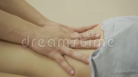 年轻女子在美容水疗中心用手按摩放松伪装者和客户一起工作视频的预览图