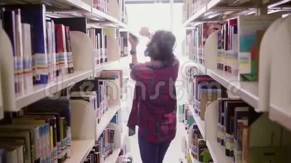 女人一边听音乐一边在图书馆跳舞视频的预览图